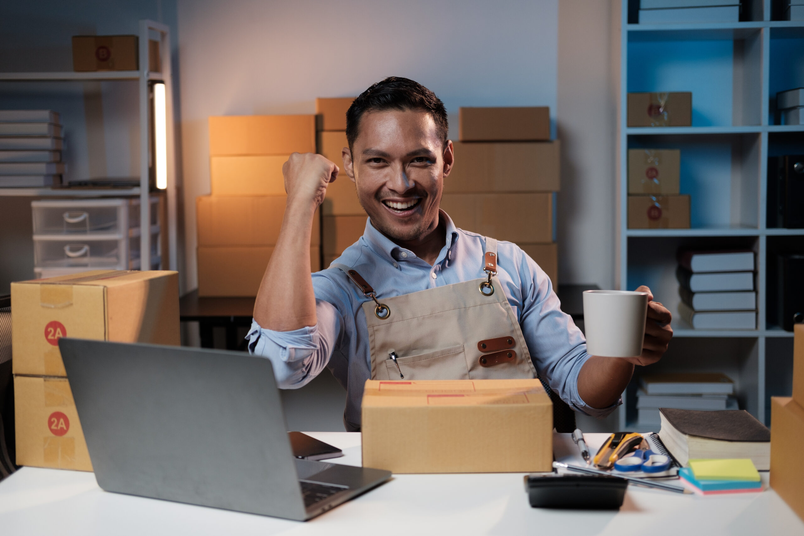 successful asian sme shop owner celebrating with h hmnxm3a scaled.jpg